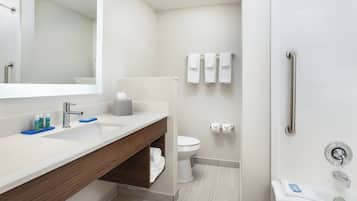 A modern bathroom with a vanity, a toilet, and a shower area.