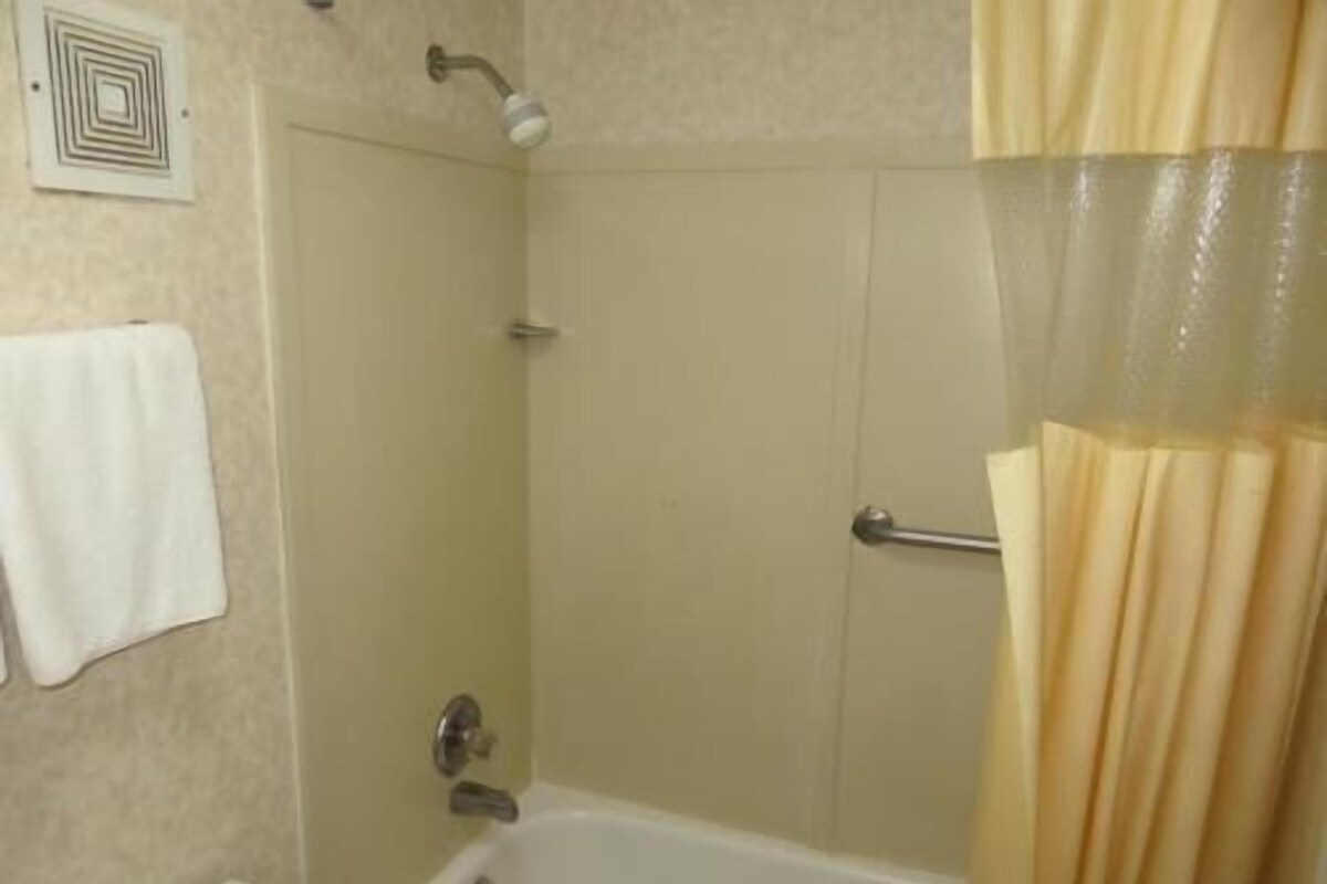 Un baño con bañera, ducha y retrete.