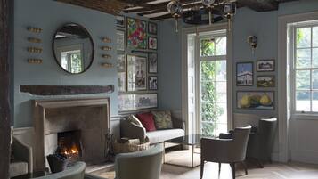 A cozy living room with a fireplace, comfortable seating, and artwork on the walls.