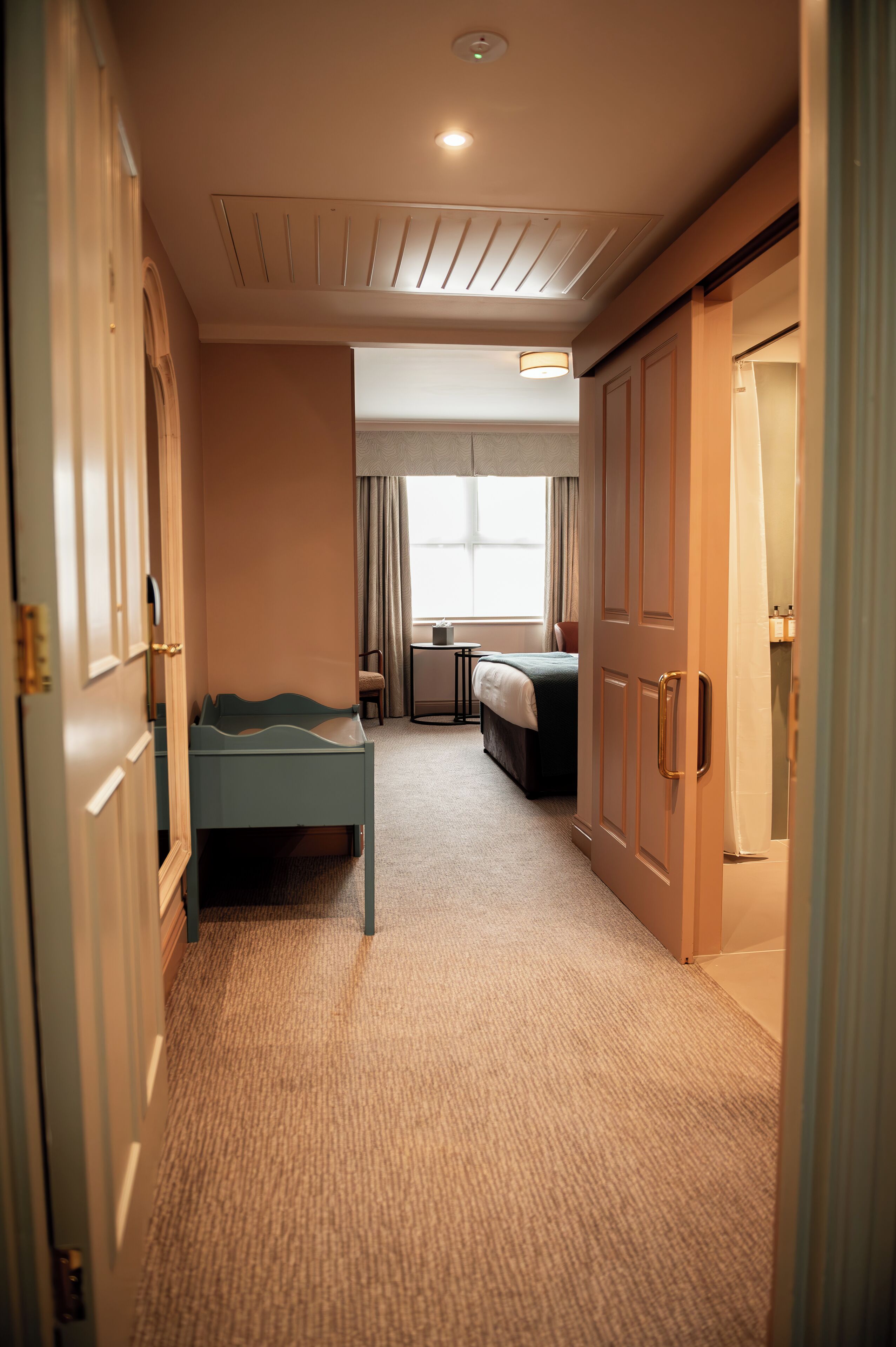 Una habitación de hotel con cama, escritorio, silla y un pequeño rincón de descanso.
