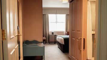 Una habitación de hotel con cama, escritorio, silla y un pequeño rincón de descanso.