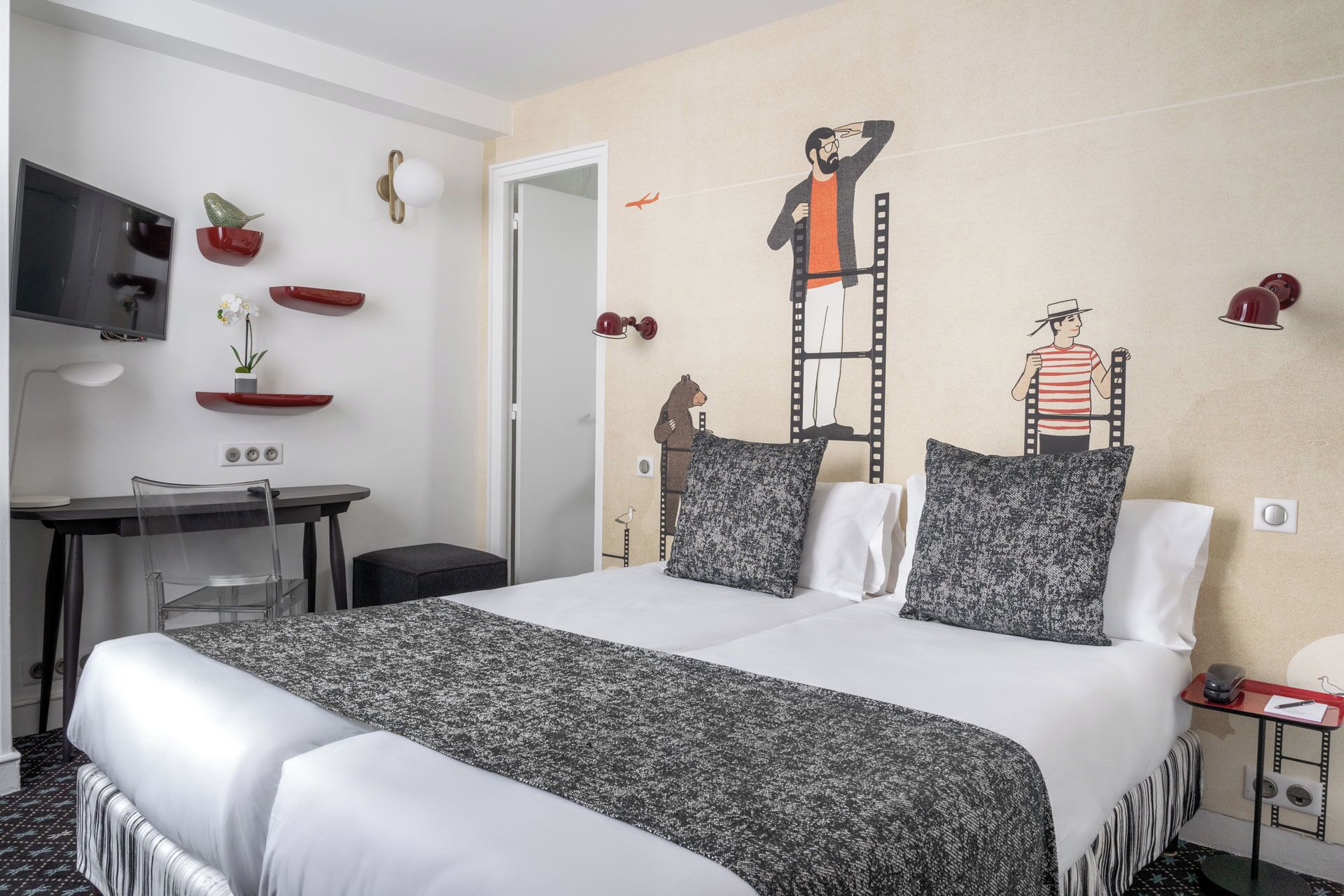 A hotel room with a bed, a desk, a chair, and a TV.