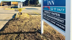 A sign for Mayfair Inn advertising weekly rates and new management. - Mayfair Inn (Williamston)