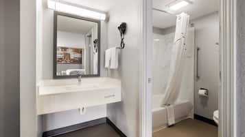 A modern bathroom with a white sink, mirror, and shower curtain.