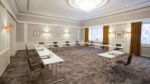 A conference room with a long table, chairs, and a chandelier.