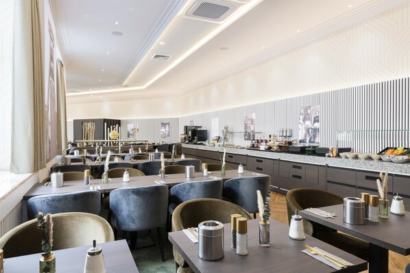 A modern restaurant with multiple dining tables and chairs, a kitchen area, and a patterned wall. - Hotel Essener Hof, BW Signature Collection (Essen)
