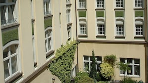 A multi-story building with a central courtyard, featuring a mix of architectural styles with arched windows and a tower-like structure.