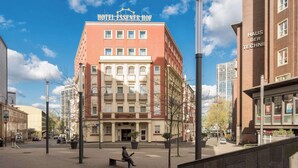 Un hôtel à la façade rouge, avec de nombreux étages, et une enseigne indiquant « HÔTEL ESSENER HOF ».