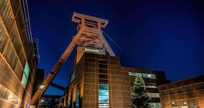 Een modern gebouw met een opvallende metalen constructie en een kerstboom.