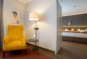 Relax in a stylish room with a comfortable armchair, a cozy bed, and a beautiful piece of artwork.