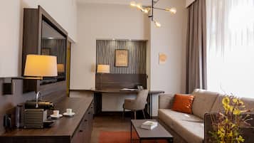 Una habitación de hotel moderna con escritorio, sofá y un espejo grande.