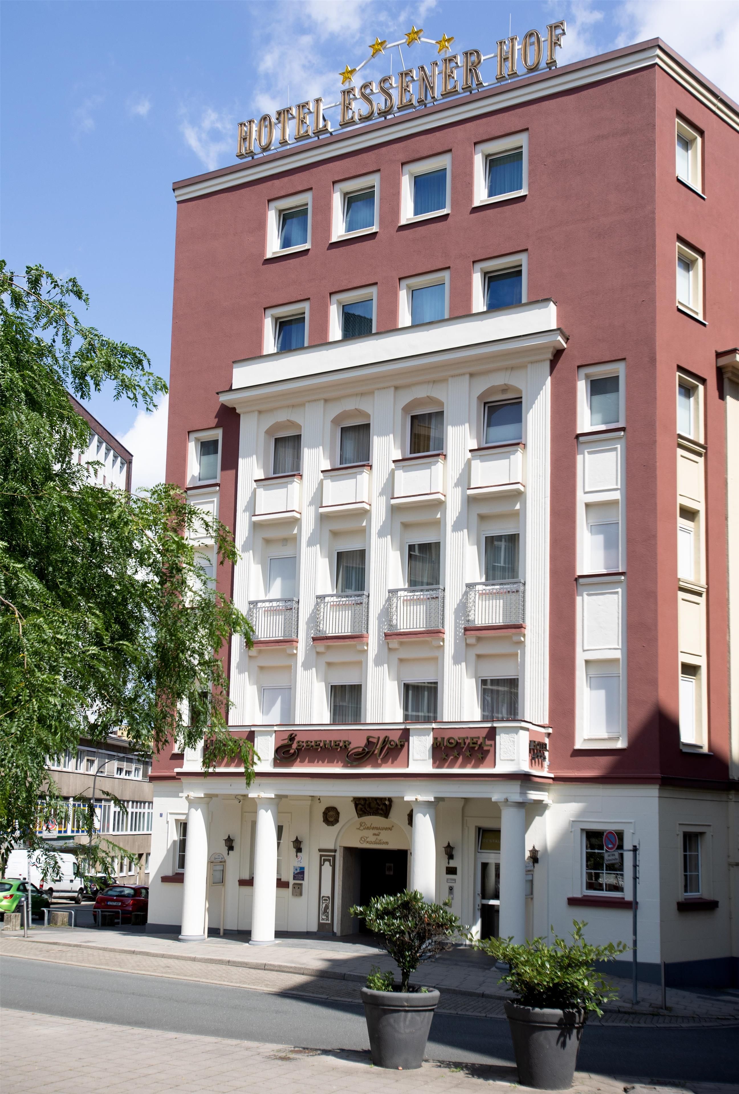 Um hotel com fachada vermelha, várias janelas e uma placa indicando 'HOTEL ESSENER HOF'.