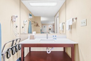 A bathroom with a white sink, a mirror, and a towel rack. - Magnolia Inn Townhouse Hattiesburg MS I-59 (Hattiesburg)