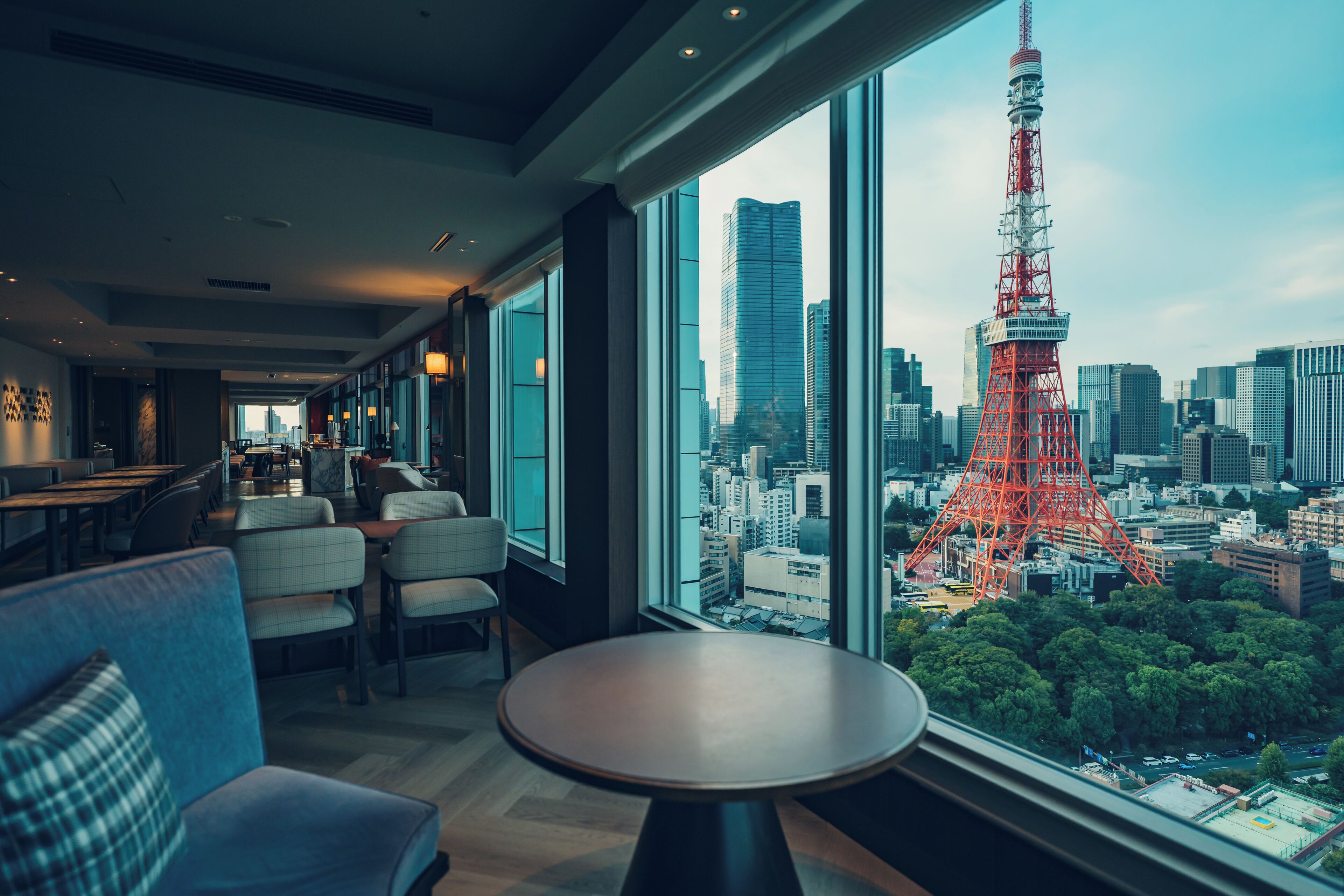A modern hotel interior with a large window offering a view of the Tokyo Tower and surrounding cityscape.