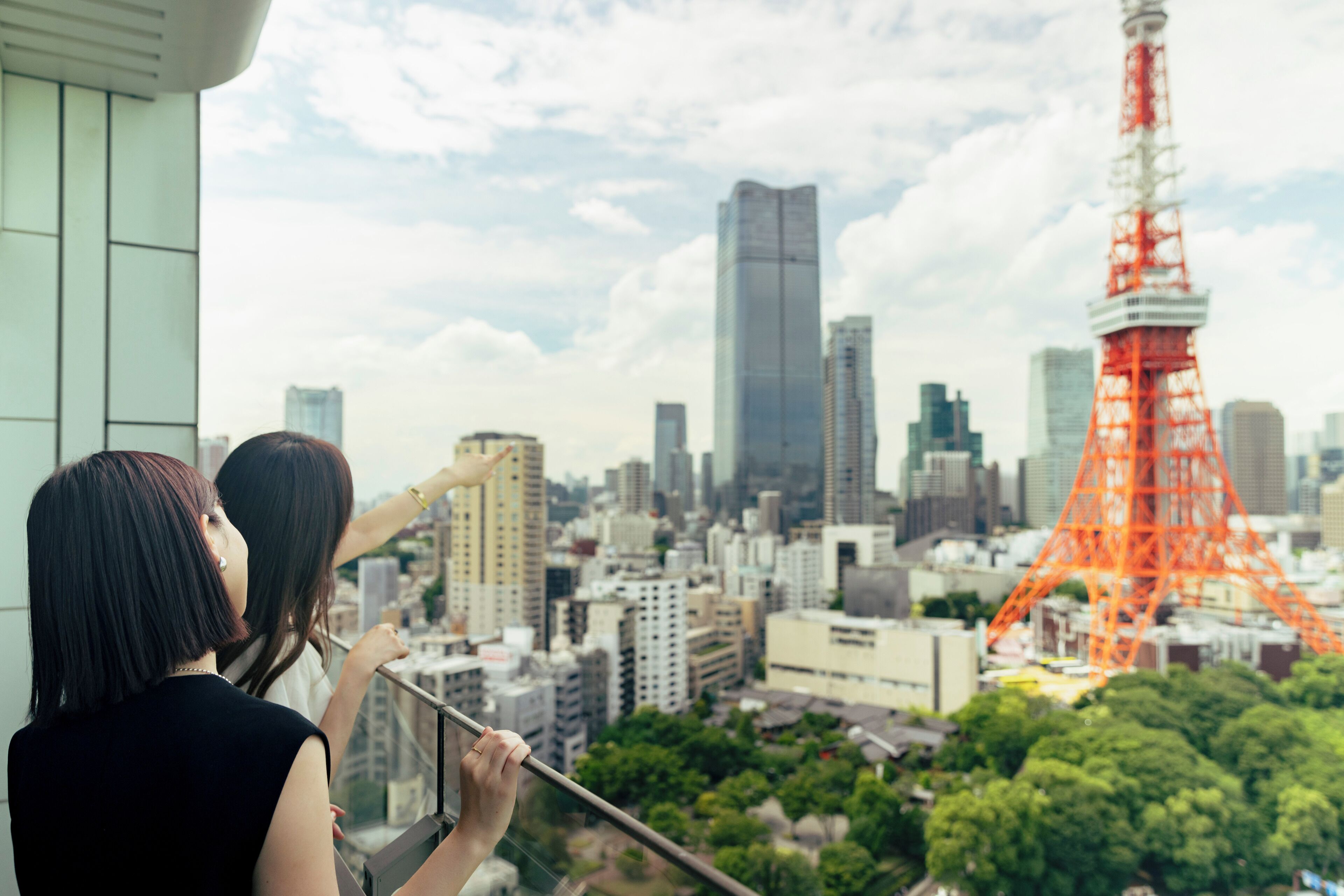A cityscape with a prominent red tower, likely a landmark, and modern buildings in the background.
