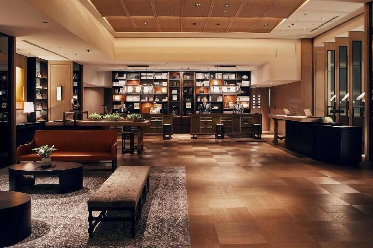 Un hall d’entrée spacieux, doté d’un sol à carreaux, d’un canapé, d’une table basse et d’une bibliothèque remplie de livres.