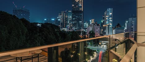 A nighttime cityscape with modern buildings and a road with light trails.
