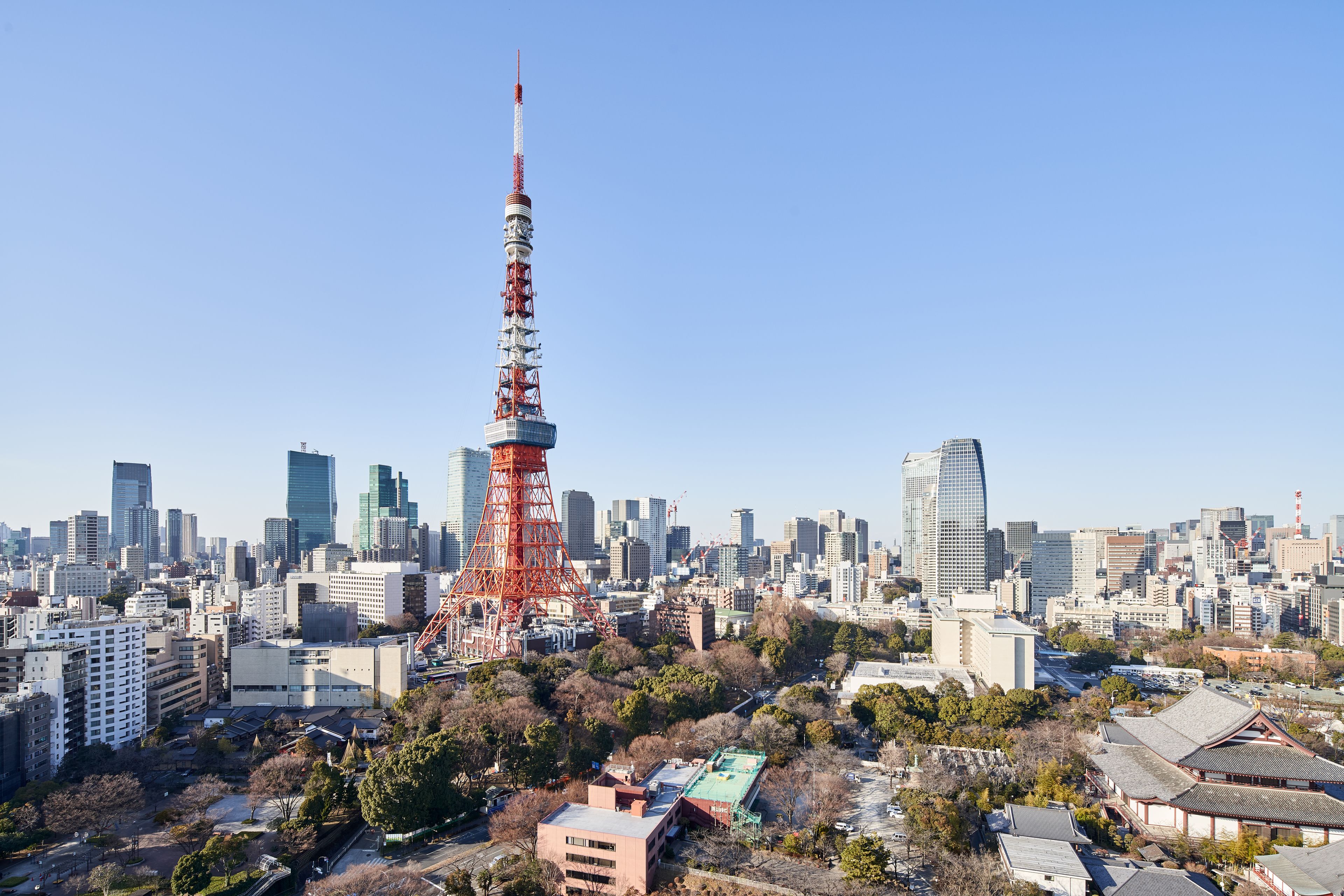 A cityscape with a prominent red tower, surrounded by modern buildings and traditional architecture.