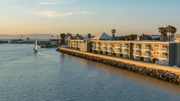 Guests enjoy waterfront views from balconies overlooking the marina and surrounding palm trees.