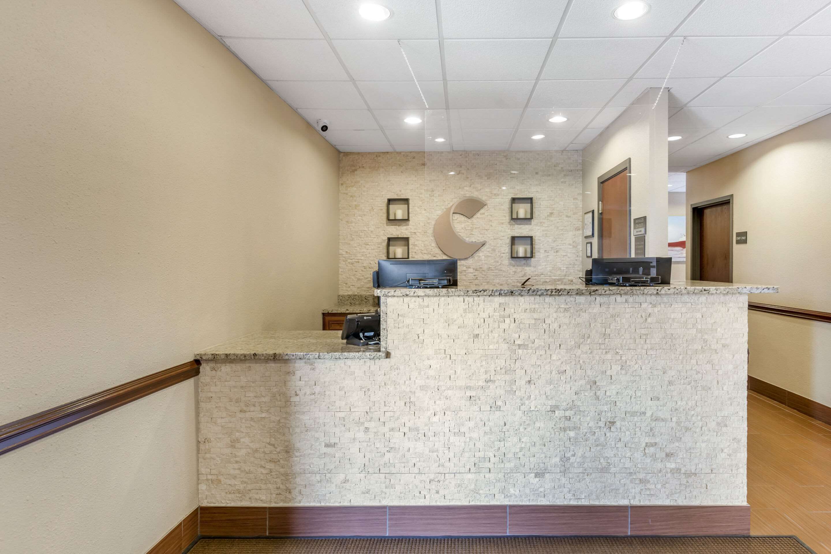 A reception area with a marble counter, a wooden bench, and a wall-mounted clock.