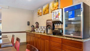 A breakfast area with a coffee machine, a refrigerator, and a sign indicating items are refrigerated.
