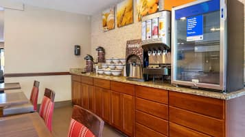 A breakfast area with a coffee machine, a refrigerator, and a sign indicating items are refrigerated.