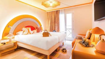 Une chambre d’hôtel comprenant un lit, une table de chevet, un bureau avec une lampe, une chaise et un téléviseur.