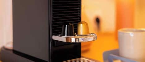 A coffee machine with a cup holder and a coffee cup on a table.