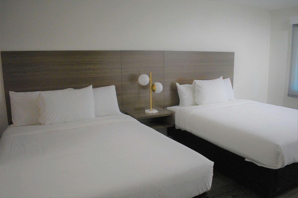 Escritorio, cortinas blackout y tabla de planchar con plancha