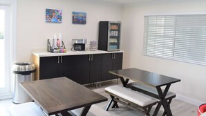 A modern kitchen with a dining table, bench, refrigerator, and coffee maker. - Signature Anaheim Maingate (Anaheim)