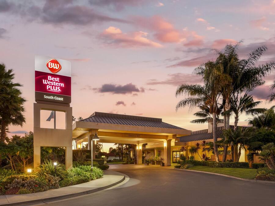 A hotel entrance with a sign reading "Best Western Plus South Coast" and a covered parking area.