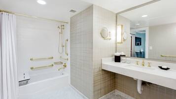 Un bagno moderno con una vasca, uno specchio grande e un mobile lavabo.