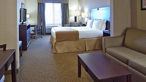 A hotel room with a bed, a sofa, a desk, a television, and a window with curtains. - Blue Way Inn Eagan Extended Stay Minneapolis Airport Eagan North MN (Eagan)