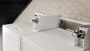 Una cocina moderna con encimera blanca, una cafetera y un electrodoméstico de marca.