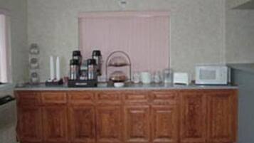 A kitchen with wooden cabinets, a microwave, and a coffee maker on the counter.