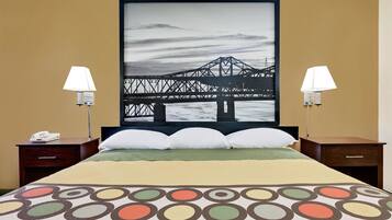 Relax in a spacious room with a large bed and two bedside tables, each with a lamp and phone.