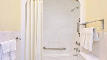 Un bagno con una vasca, una tenda da doccia, un portasciugamani e un water.