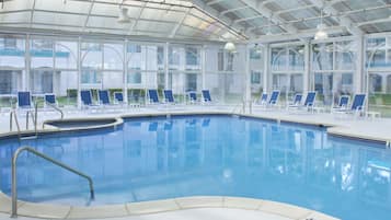 Una piscina techada, sillones reclinables de piscina