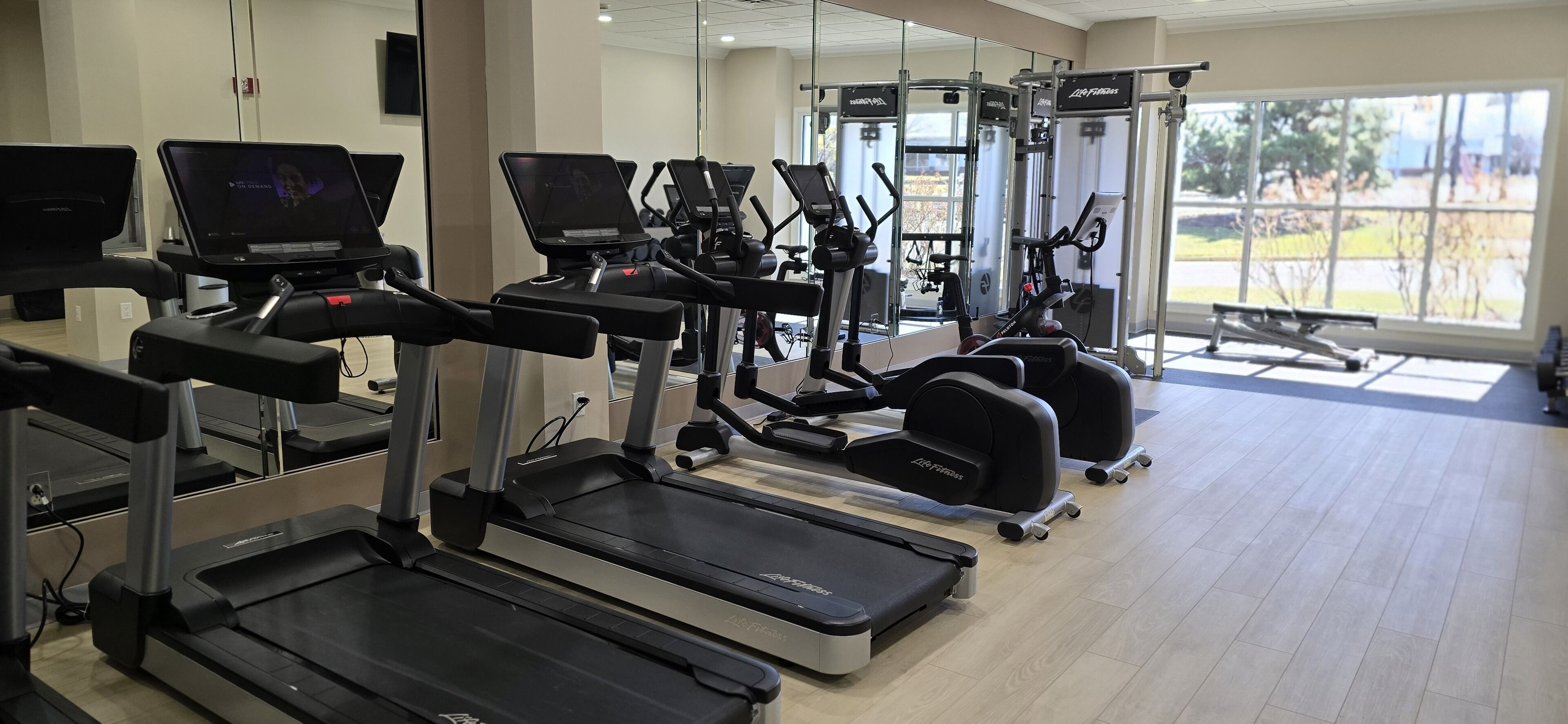 A gym with treadmills, elliptical machines, and weight equipment.