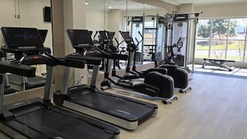 A gym with treadmills, elliptical machines, and weight equipment.