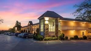 A hotel with a stone facade, large windows, and a parking lot with several cars. - Best Western Inn of the Ozarks (Eureka Springs)