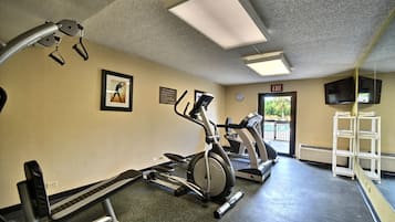 A gym with treadmills, elliptical machines, and weight benches.