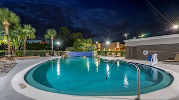 Una piscina al aire libre, sombrillas, sillones reclinables de piscina