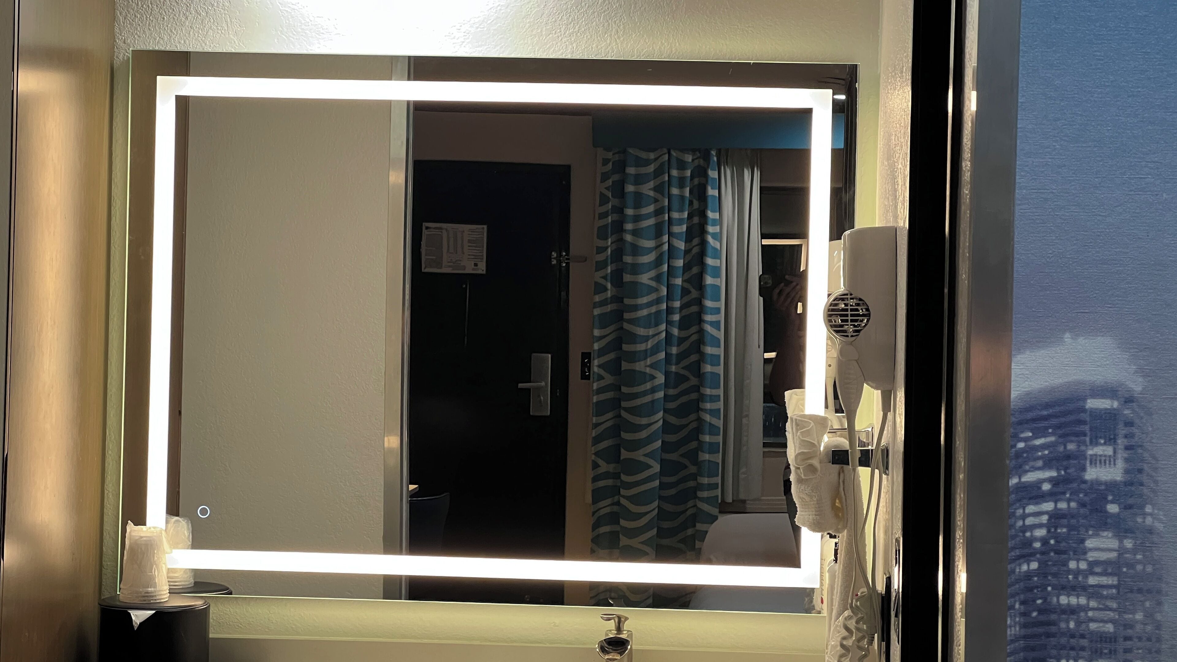 Un baño con espejo, lavamanos y cortina de ducha.