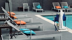 Un espace aménagé au bord de la piscine, avec des chaises longues et des parasols.