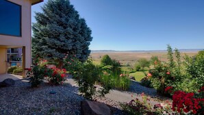 A building with a red roof, a large evergreen tree, and a gravel driveway. - Red Lion Hotel Pendleton (Pendleton)