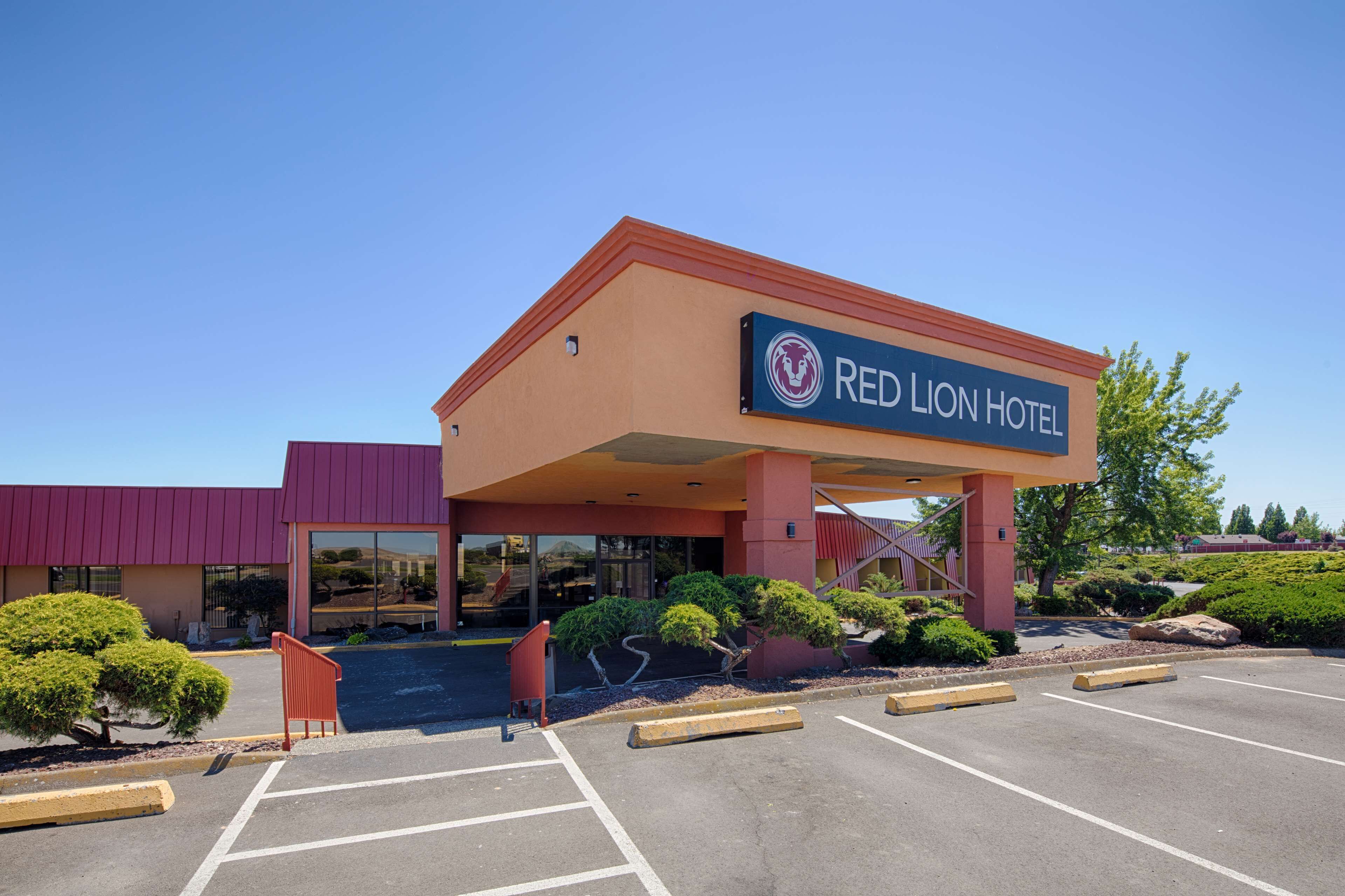 A Red Lion Hotel with a modern design, a parking lot, and landscaped areas.