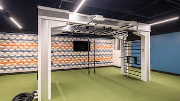 A gym with a green floor, a wall with a geometric pattern, and a black door.