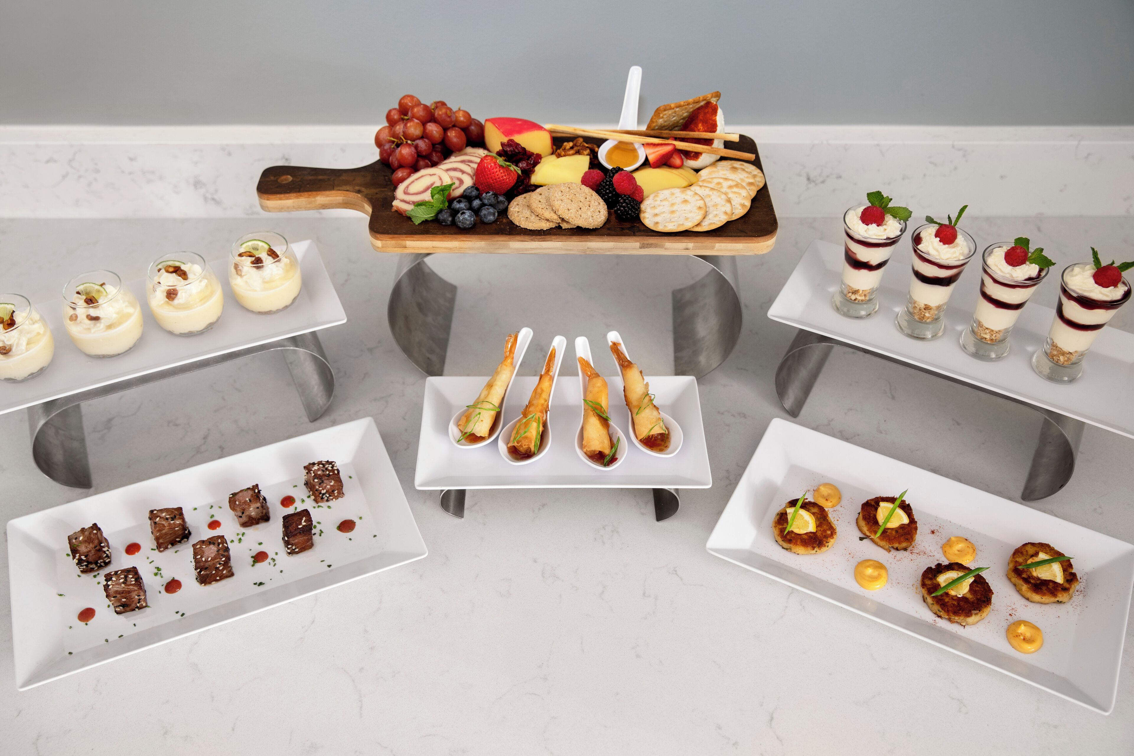Un bufé de postres con diversas golosinas y aperitivos dispuestos en múltiples fuentes.