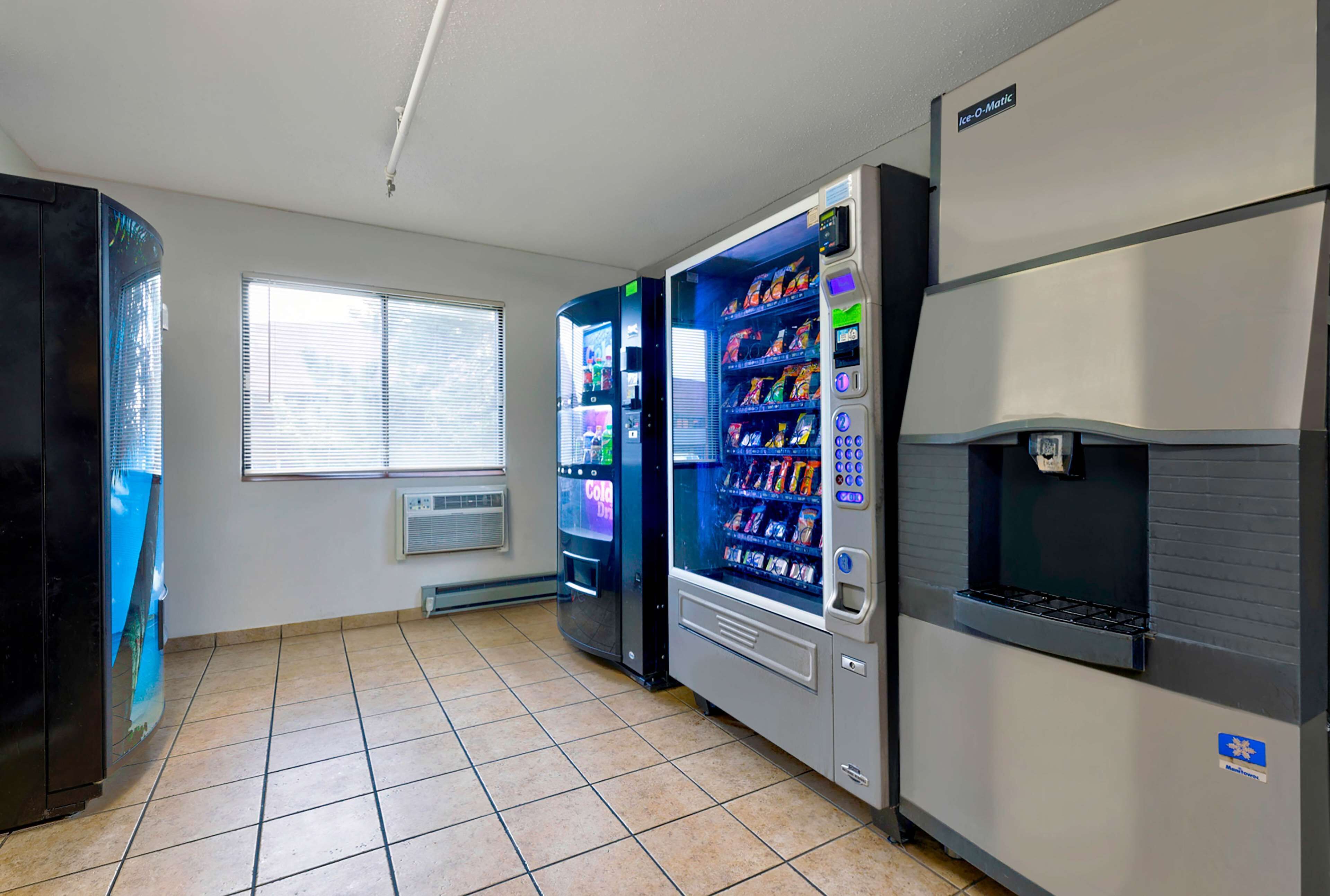 A room with vending machines, a window, and a thermostat.